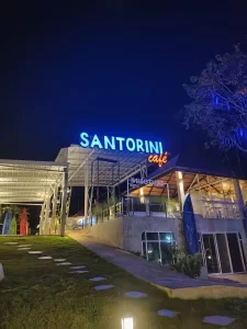 ป้ายอะคริลิค SANTORINI café บนดาดฟ้า ไฟส่องสว่างยามค่ำคืน