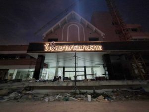 ป้ายชื่อโรงพยาบาลบางจาก ตัวอักษรสแตนเลสไฟ LED ส่องสว่างยามค่ำคืน มุมใกล้เห็นตัวอักษรเรืองแสง