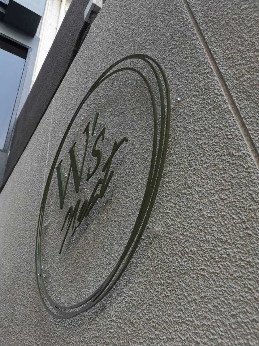 โลโก้วงกลม W s Nest สแตนเลสฉลุ ติดผนังปูนเปลือยสีเทา สไตล์มินิมอล ผลิตโดย Scinage