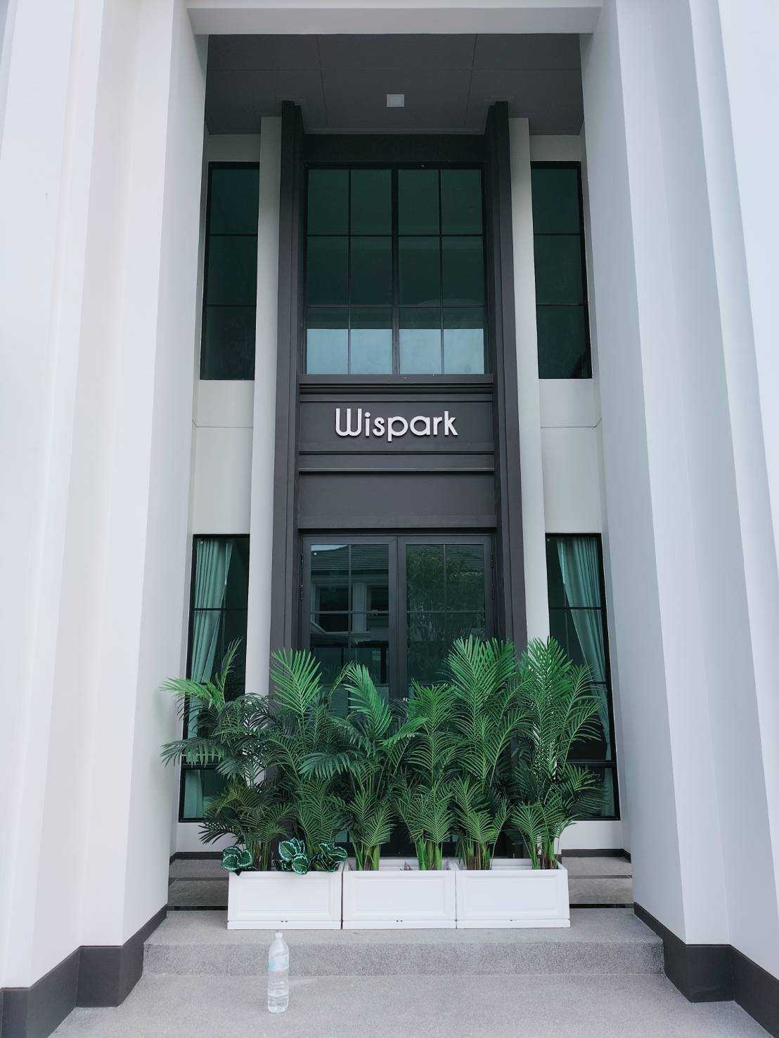 ป้ายตัวอักษรสแตนเลสนูน Wispark ติดเหนือประตูกระจก อาคารโมเดิร์นสีขาว งานคุณภาพระดับพรีเมียม ผลิตโดย Scinage